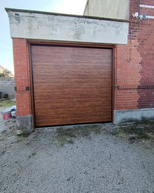 Porte de garage sectionnelle imitation bois installée par Fermotek