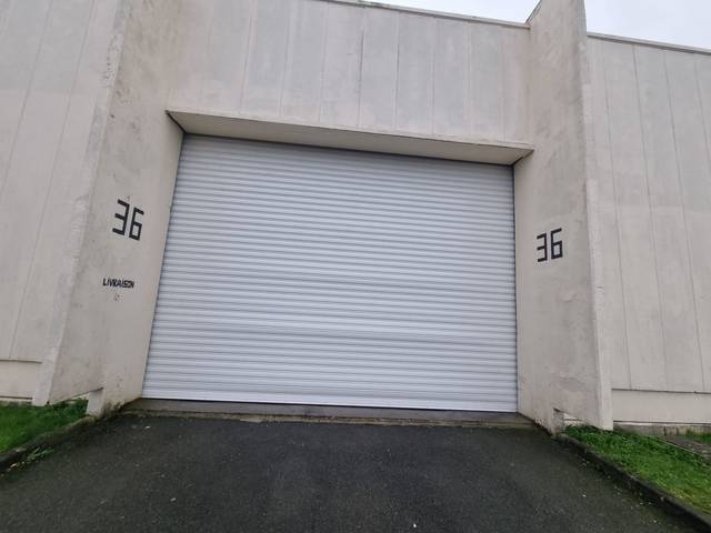Rideau métallique anthracite installé sur façade brique par Fermotek
